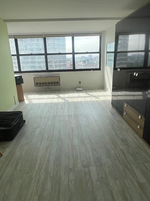 7004 Boulevard East, Unit 30G Guttenberg, NJ 07093 - Photo 14 of 34 an empty room with wooden floor and a window