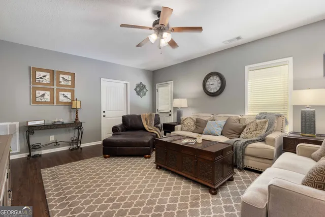 a living room with furniture a clock on wall and a table