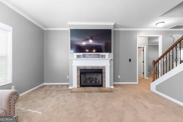 a living room with furniture a flat screen tv and a fireplace