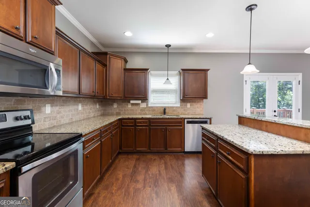 a kitchen with stainless steel appliances granite countertop wooden cabinets stove top oven and sink