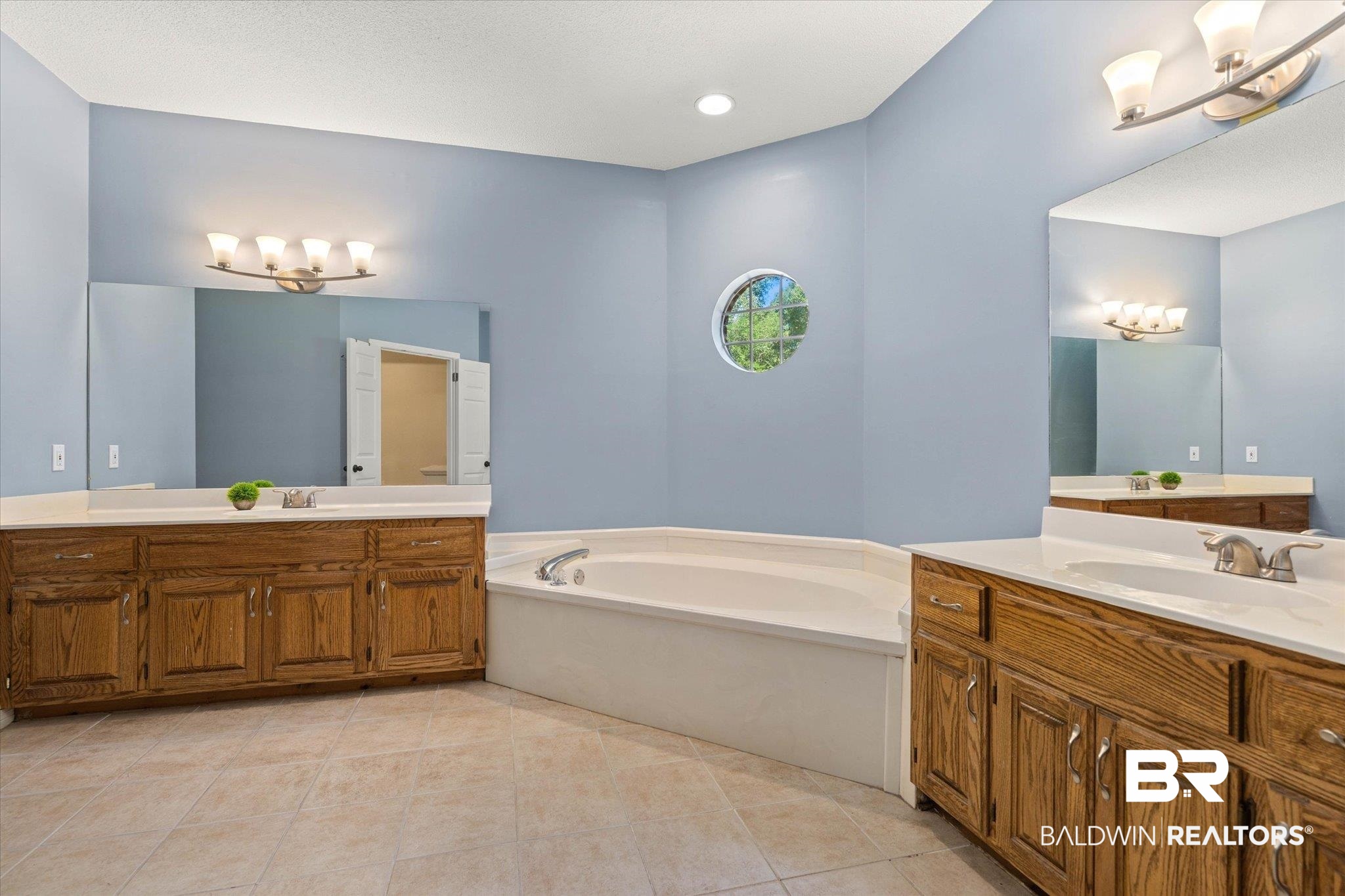 1640 Aden Road Mobile, AL 36695 - Photo 9 of 20 Bathroom featuring a garden tub, two vanities, tile patterned floors, and a chandelier