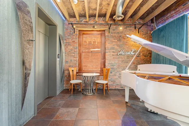 a dining room with a large window and chandelier