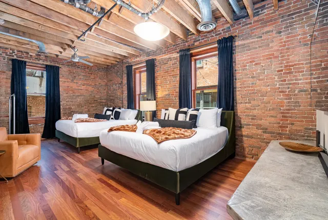 a spacious bedroom with a bed and wooden floor