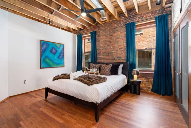 a bedroom with a bed and a dresser next to a window