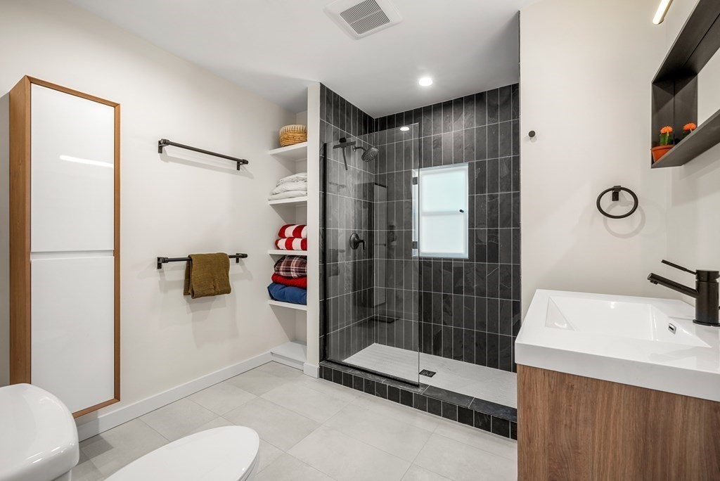 261 West Fifth Street, Unit 2 Boston, MA 02127 - Photo 27 of 31 a bathroom with a shower sink and mirror