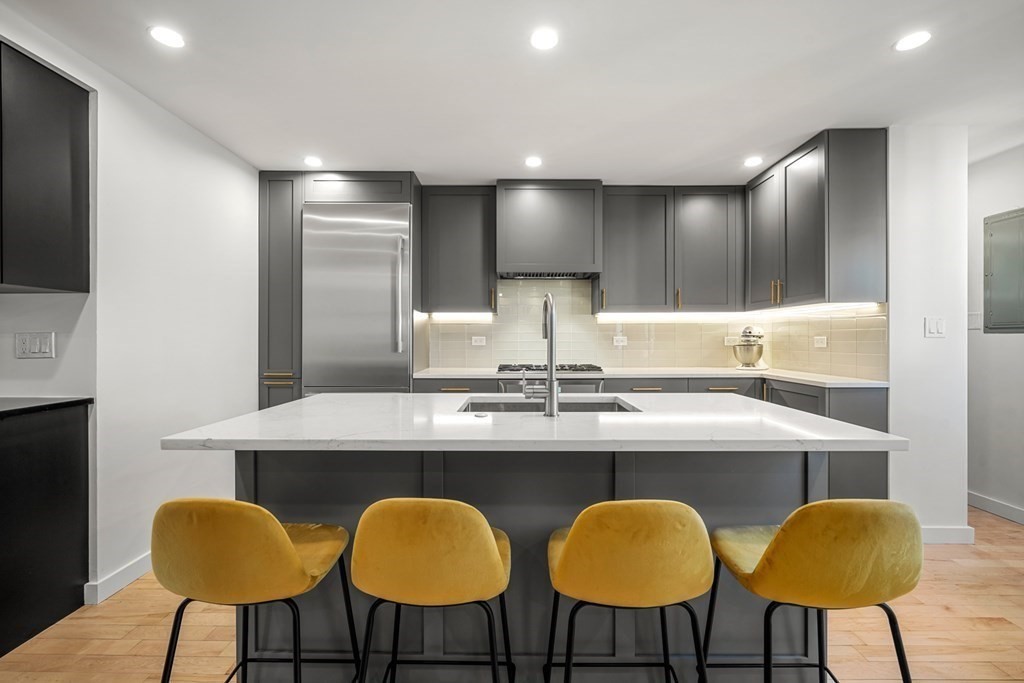 261 West Fifth Street, Unit 2 Boston, MA 02127 - Photo 4 of 31 a kitchen with chairs a sink and chairs in it