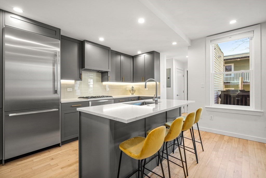 261 West Fifth Street, Unit 2 Boston, MA 02127 - Photo 5 of 31 a kitchen with kitchen island a large window and chairs
