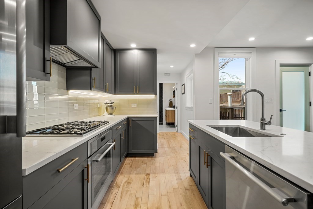 261 West Fifth Street, Unit 2 Boston, MA 02127 - Photo 6 of 31 a kitchen with kitchen island stainless steel appliances a sink stove and cabinets