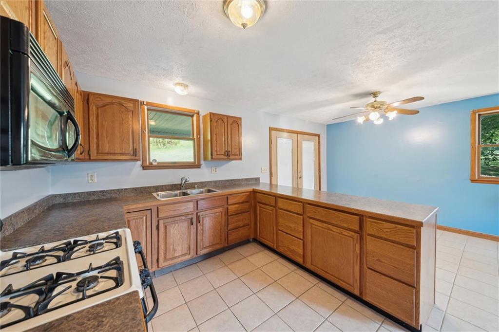 826 Pony Farm Road Kittanning, PA 16201 - Photo 12 of 35 a kitchen with granite countertop a sink stainless steel appliances and cabinets