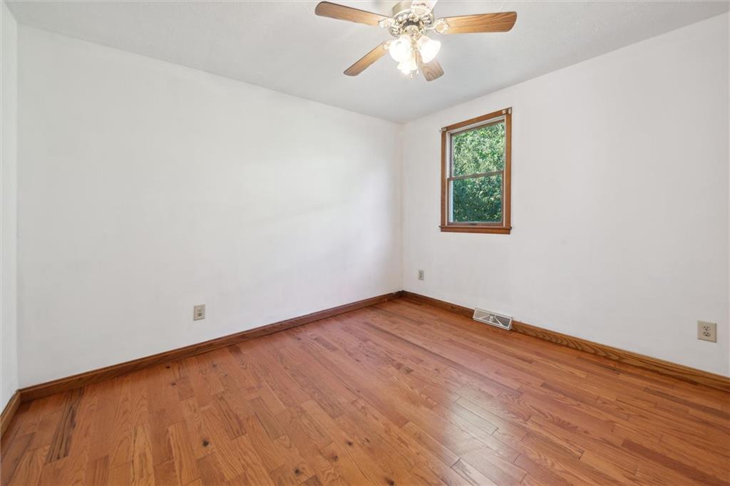 826 Pony Farm Road Kittanning, PA 16201 - Photo 14 of 35 an empty room with wooden floor chandelier fan and windows