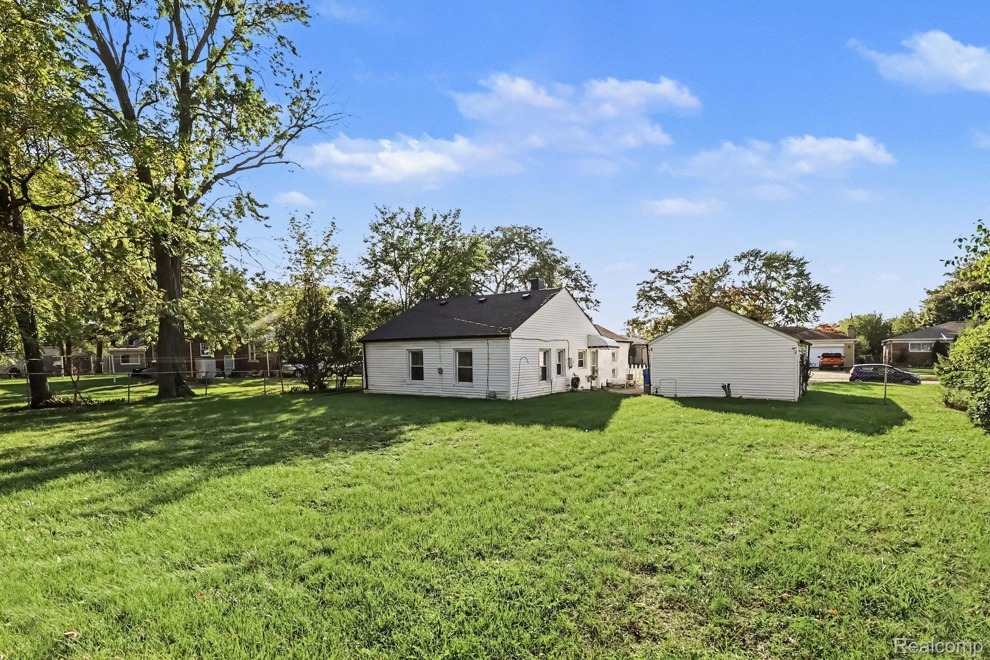 32694 Ruehle Avenue Warren, MI 48093 - Photo 14 of 15 Expansive grassy lawn with mature trees and a detached garage structure