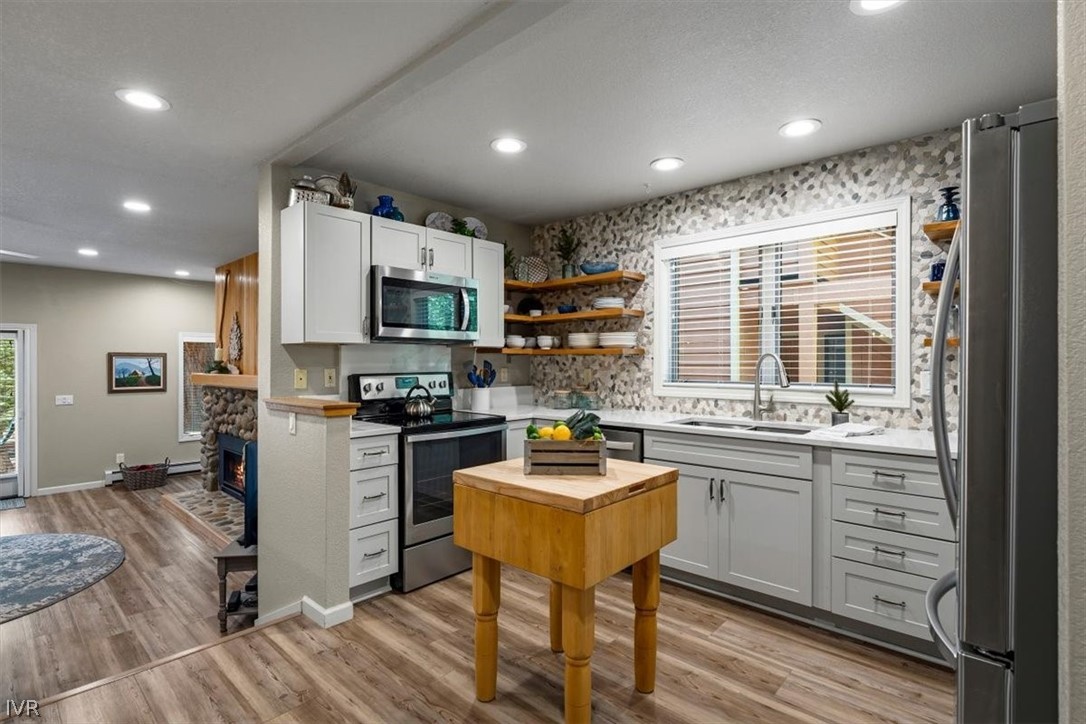 947 Incline Way, Unit 172 Incline Village, NV 89451 - Photo 10 of 30 a kitchen with stainless steel appliances granite countertop a stove top oven a sink dishwasher a dining table and chairs with wooden floor