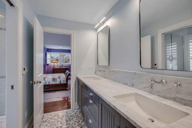 a bathroom with a granite countertop sink a mirror and shower