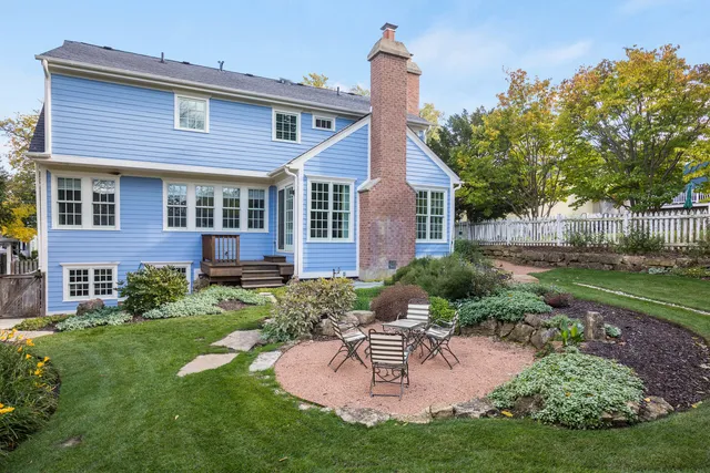 a backyard of a house with table and chairs