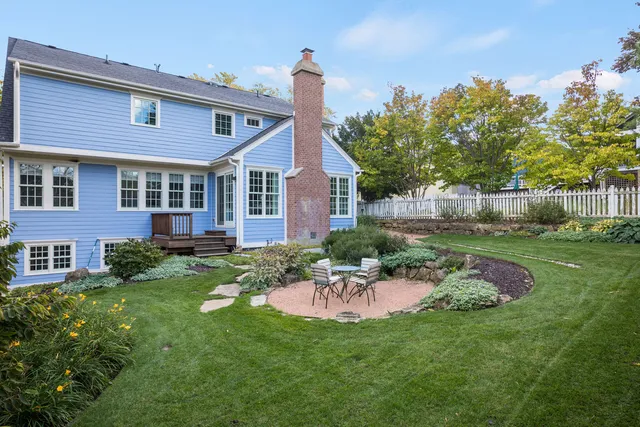 a view of a brick house with a big yard and potted plants