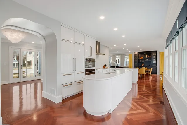 a large white kitchen with a large window