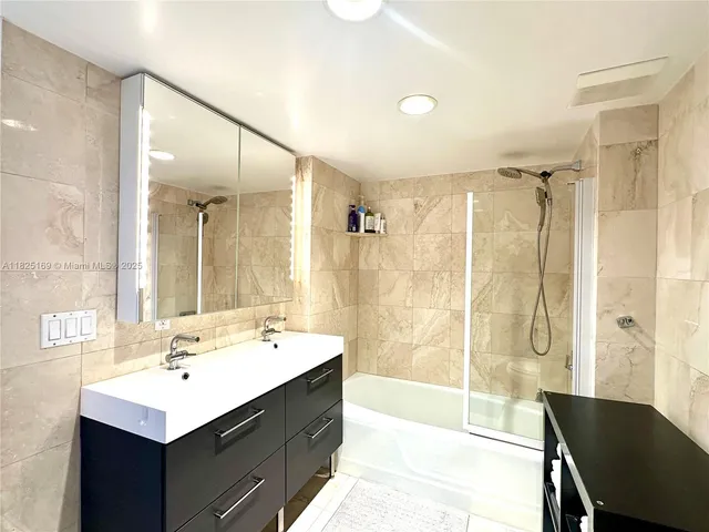 a bed sitting in a bedroom next to a window with a chandelier