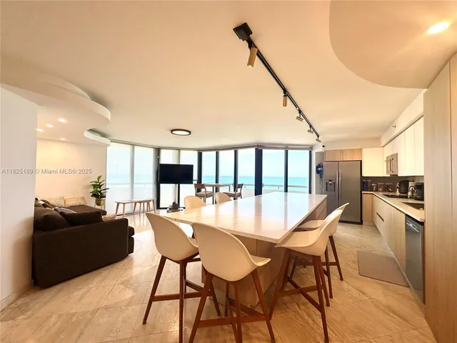 a living room with couches a coffee table and a large window with garden view