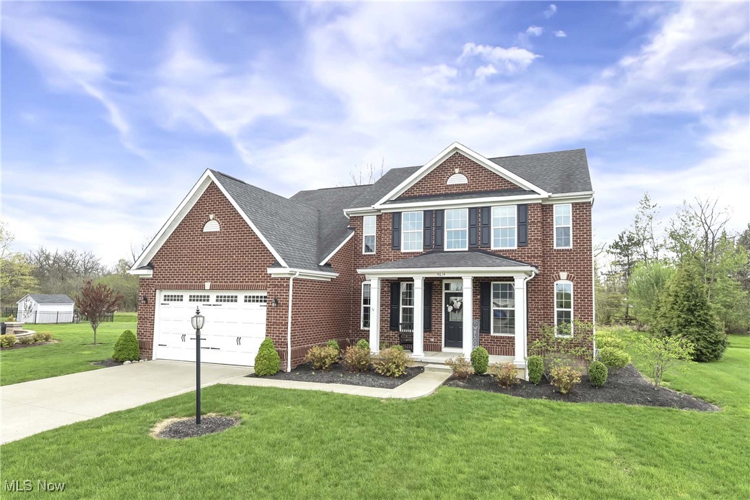 4614 Ridgestone Way Medina, OH 44256 - Photo 1 of 32 View of front of home featuring covered porch, brick siding, driveway, and a front lawn