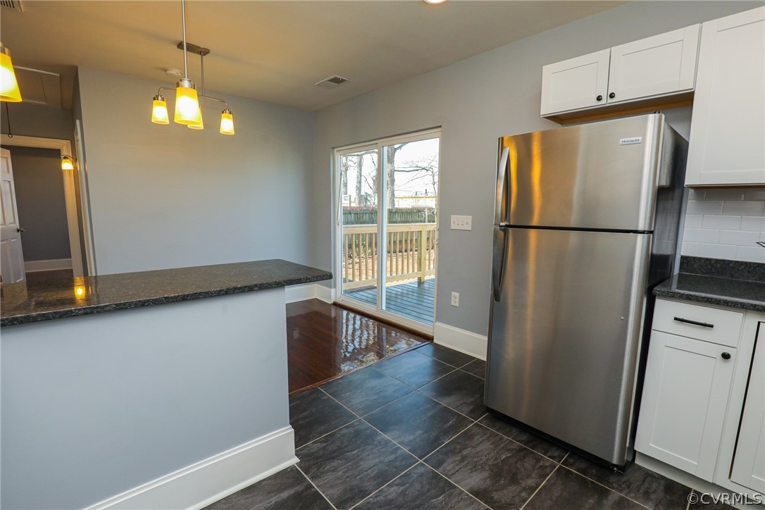3908 Decatur Street Richmond, VA 23224 - Photo 11 of 23 a view of a refrigerator in kitchen and an empty room with wooden floor