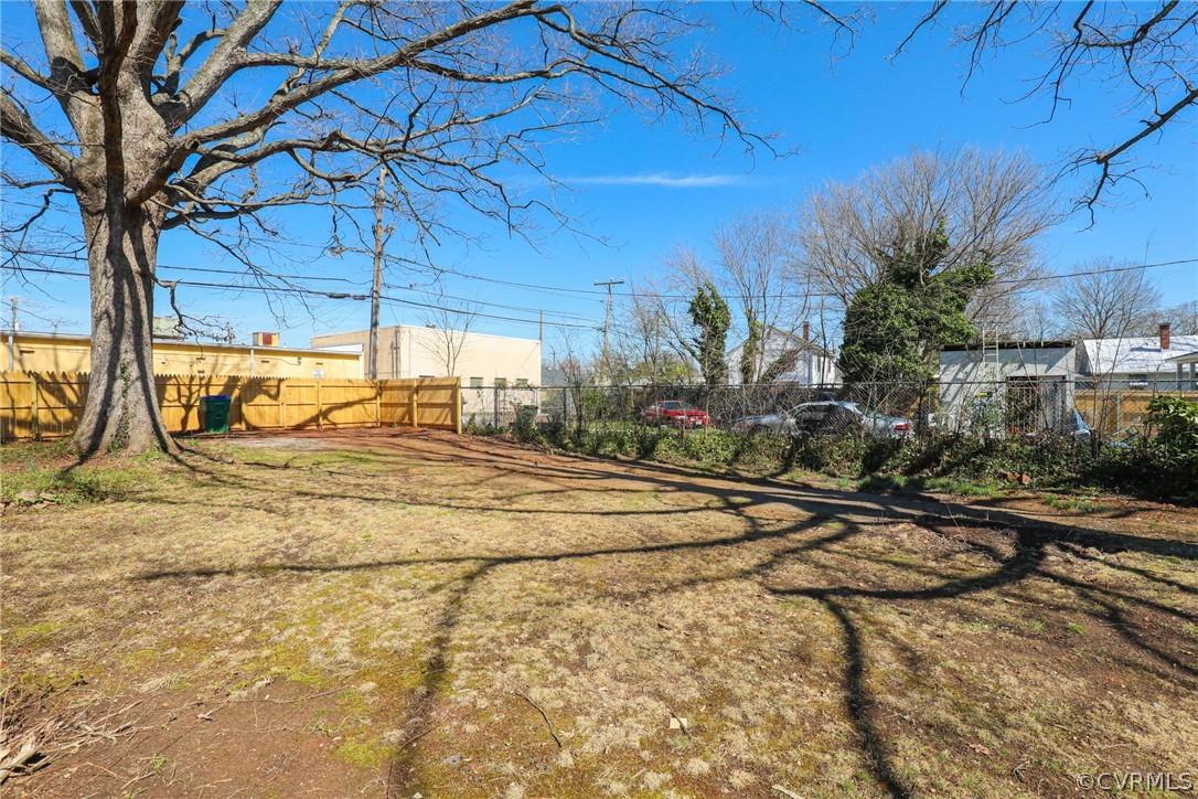 3908 Decatur Street Richmond, VA 23224 - Photo 20 of 23 a backyard of a house with table and chairs under an umbrella