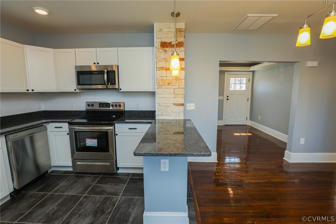 3908 Decatur Street Richmond, VA 23224 - Photo 10 of 23 a kitchen with stainless steel appliances kitchen island granite countertop a stove a sink and a microwave