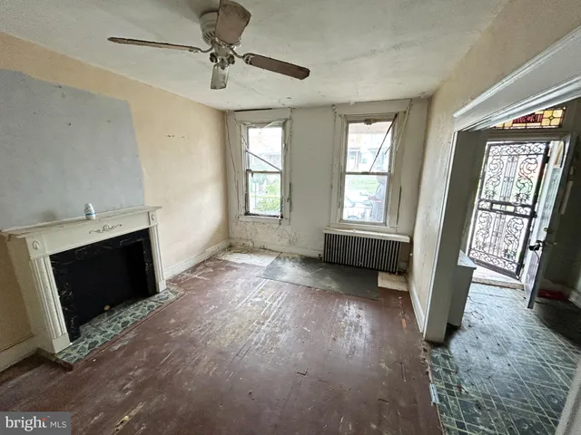 a view of an empty room with a fireplace and a window