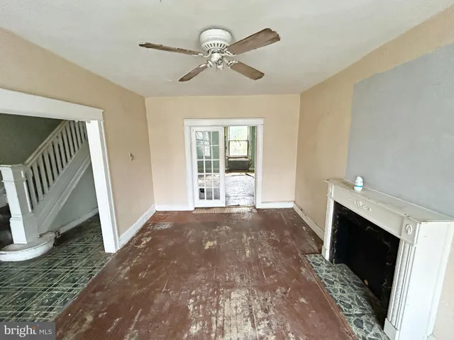 a view of an empty room with a fireplace and a window