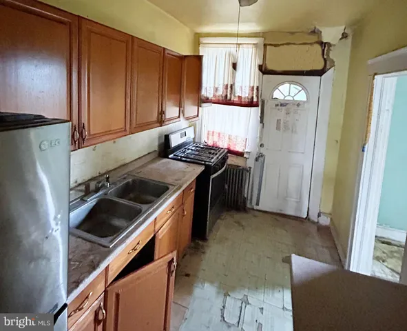 a kitchen with stainless steel appliances granite countertop a refrigerator and a stove top oven