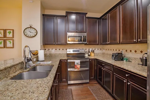 a kitchen with a sink stove top oven and cabinets
