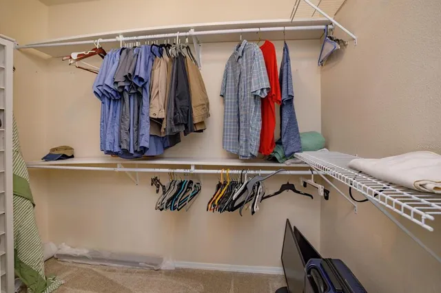 a view of walk in closet with clothes
