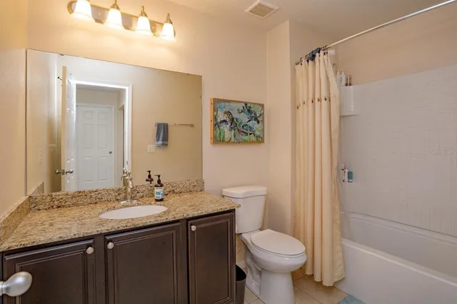 a bathroom with a granite countertop toilet sink and a mirror