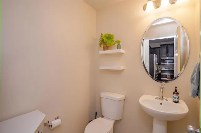 a bathroom with a toilet sink and mirror