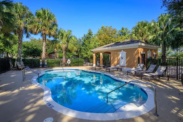 a view of a house with backyard swimming pool and sitting area