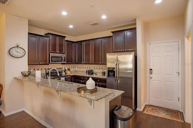 a kitchen with a refrigerator sink and cabinets