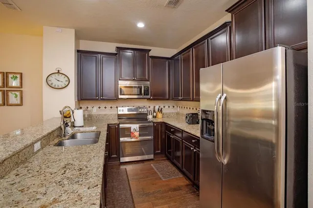 a kitchen with stainless steel appliances granite countertop a refrigerator stove a sink and dishwasher