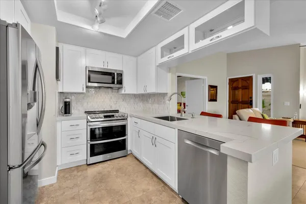 a kitchen with stainless steel appliances a stove sink microwave and refrigerator