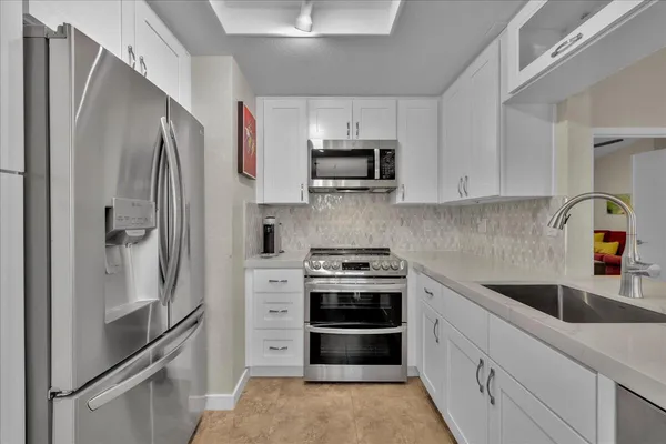 a kitchen with stainless steel appliances and cabinets