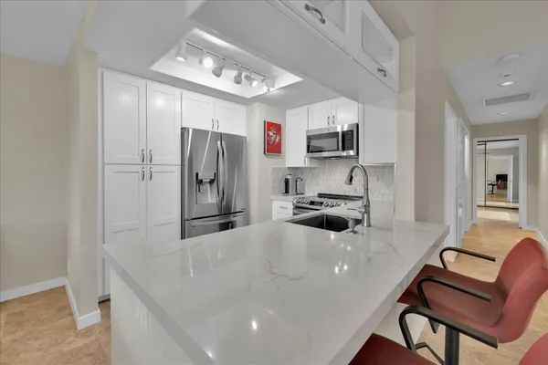a kitchen with stainless steel appliances a refrigerator and a stove top oven