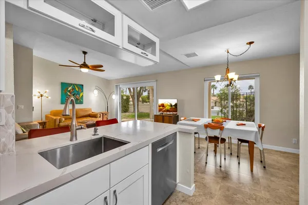 a kitchen with a table chairs and white cabinets