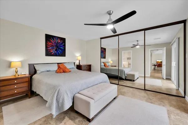 a spacious bedroom with a bed and a lamp