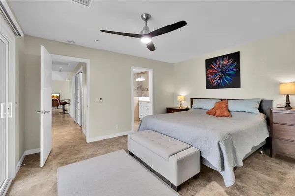 a bedroom with a large bed and a chandelier