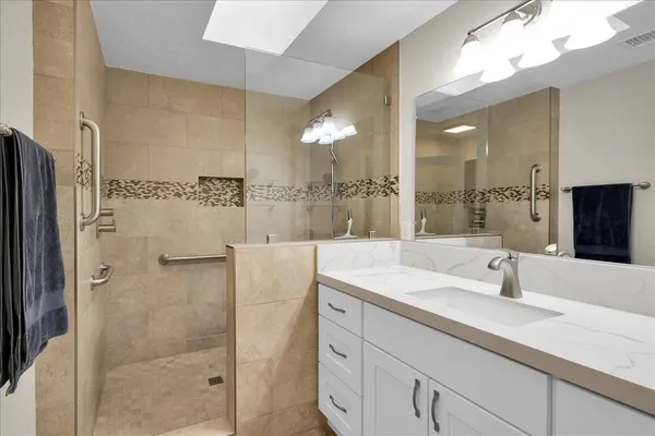 a bathroom with a shower sink and mirror