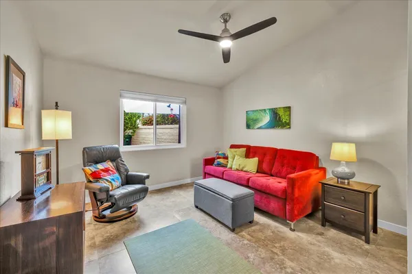 a living room with furniture a flat screen tv and a lamp