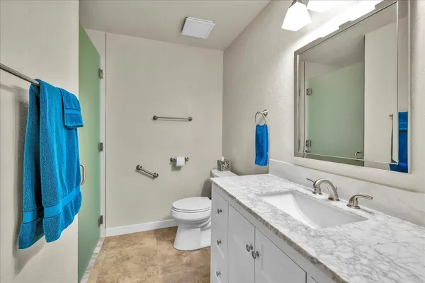 a bathroom with a granite countertop sink and a mirror
