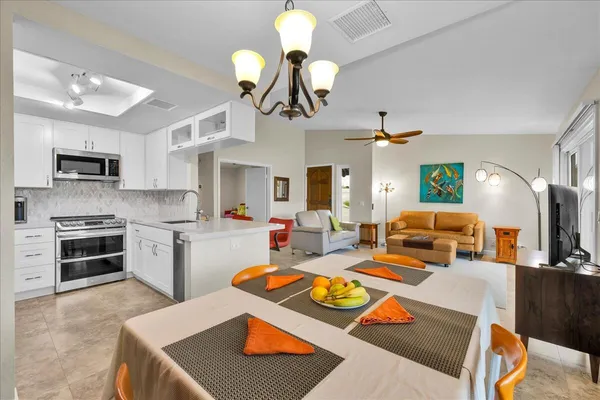 a living room with kitchen island furniture and a chandelier