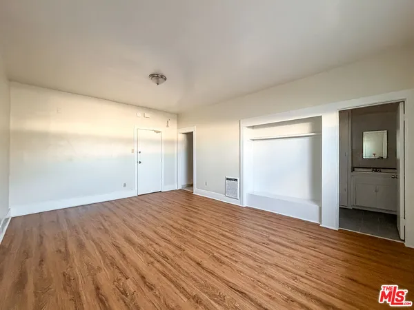 a view of empty room with wooden floor