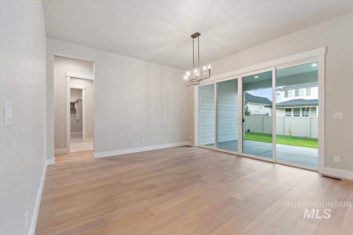 2147 East Blakehurst Avenue Kuna, ID 83634 - Photo 17 of 43 Unfurnished dining area with light wood-type flooring and a chandelier