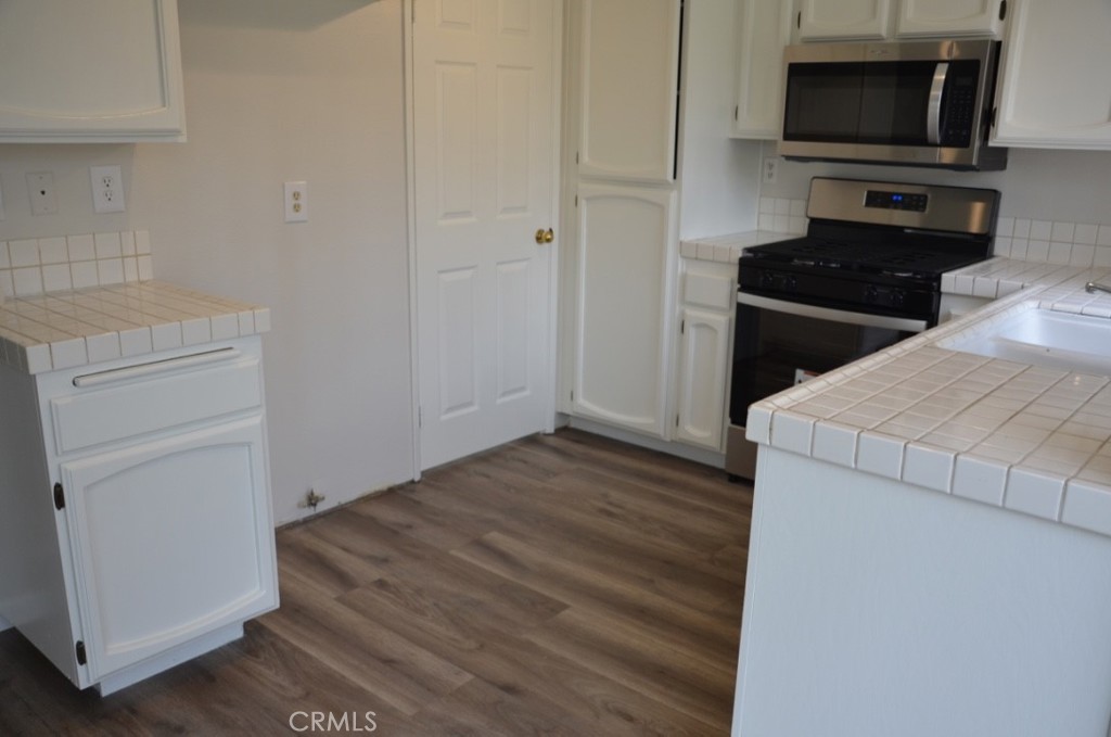 29620 Nightcrest Circle Temecula, CA 92591 - Photo 10 of 31 a kitchen with wooden floor and black appliances