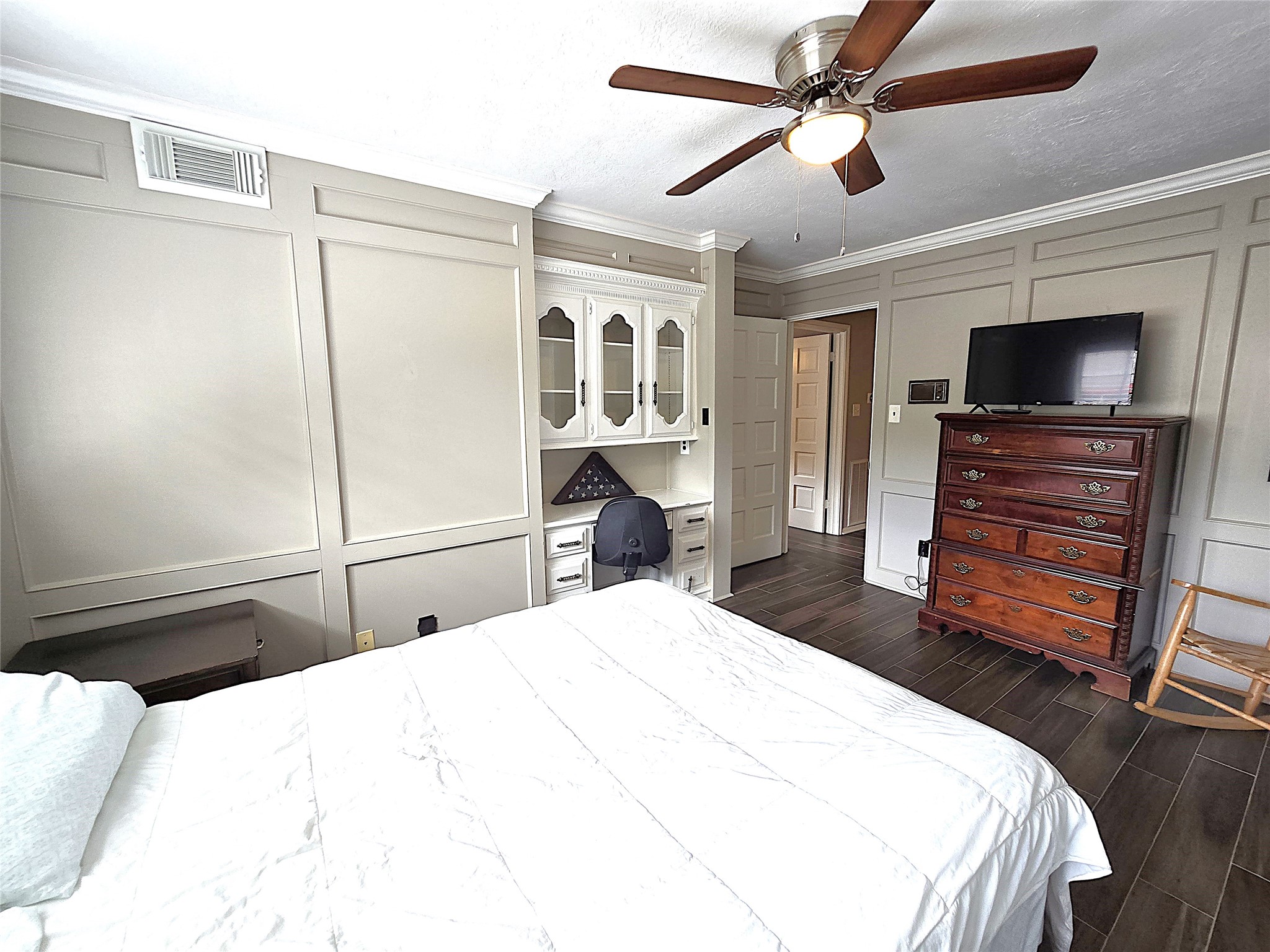 560 Brandon Road Conroe, TX 77302 - Photo 35 of 45 Comfortable second bedroom featuring elegant paneling, built-in storage, and a ceiling fan for year-round comfort.